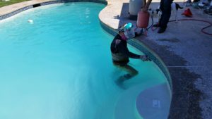 Man cleaning pool tile. Bay Area Pool Tile Cleaning